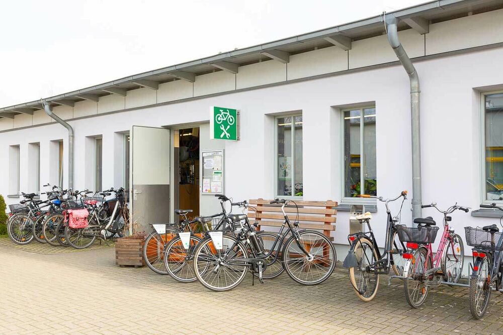 Das Gebäude der Fahrradwerkstatt von außen und davor einige Fahrräder