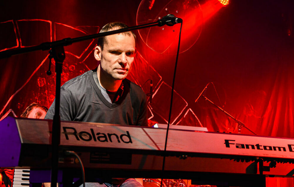 Marco Simanowski sitzt bei einem Konzert am Keyboard