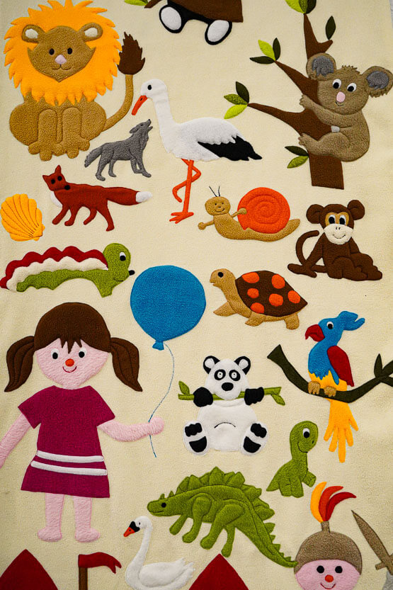 Eine Decke mit vielen Tiermotiven, dabei ist ein Löwe, eine Schildkröte, ein Koala-Bär und viele andere Tiere