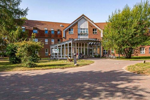 Pflegeheim Züssow mit Vorplatz und flankiert von Bäumen