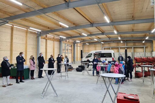 Eine Gruppe von Menschen steht mir einigen Tischen in der neuen Halle