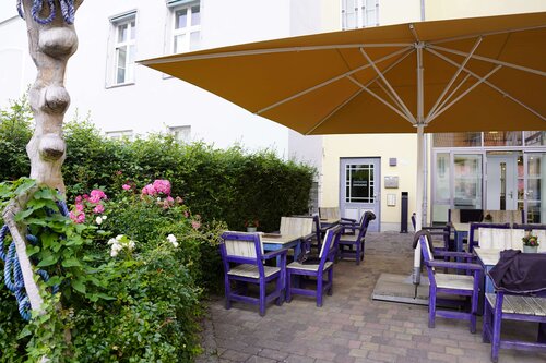 Innenhof des Cafe und Restaurant Lichtblick mit Esstischen, Schirmen und Stühlen