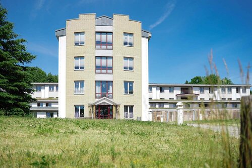 Südfassade des Hauptgebäudes mit vier Stockwerken und Fenstern