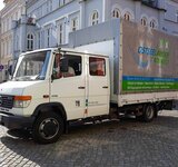 Ein großer LKW mit Plane steht vor Gebäuden auf dem Greifswalder Marktplatz