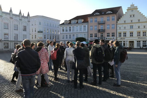 Die Teilnehmenden des Spaziergangs stehen auf dem Marktplatz