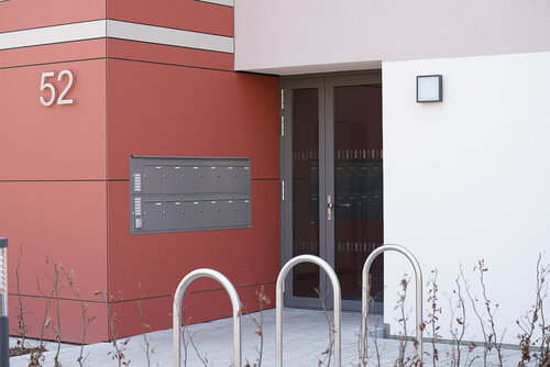 Blick in denen Hauseingang mit einer großen Briefkastenanlage an der Wand und davor Fahrradbügel