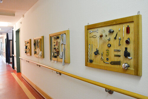 Im Flur hängen Schaukästen mit ergotherapeutischen Werkzeugen