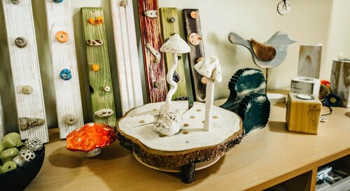 Kunstvolle Holzpilze stehen auf einem ausgesägten Baumstamm