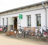 Das Gebäude der Fahrradwerkstatt von außen und davor einige Fahrräder