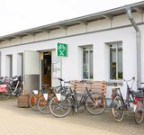 Das Gebäude der Fahrradwerkstatt von außen und davor einige Fahrräder