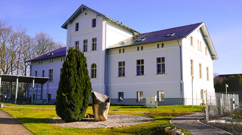 Außenaufnahme des Gutshauses in Groß Lehmhagen mit Auffahrt und Bepflanzung