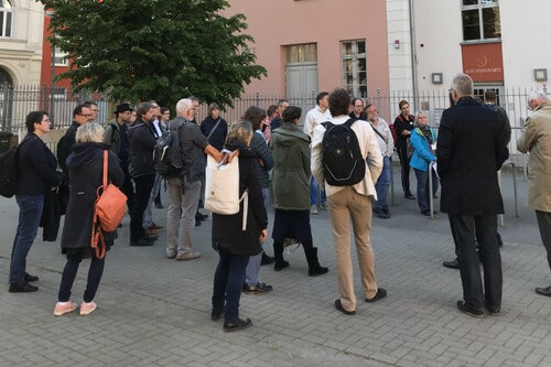 Die Teilnehmenden des Rundgangs stehen vor einem Gebäude