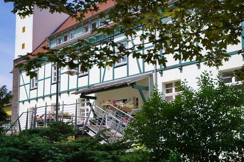 Rückansicht des Pflegeheims mit Eingangsbereich, Fachwerkfassade und einem kleinen Turm am linken Ende des Gebäudes