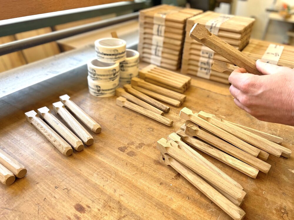 Von Hand gefertigte Holzstäbe werden sortiert