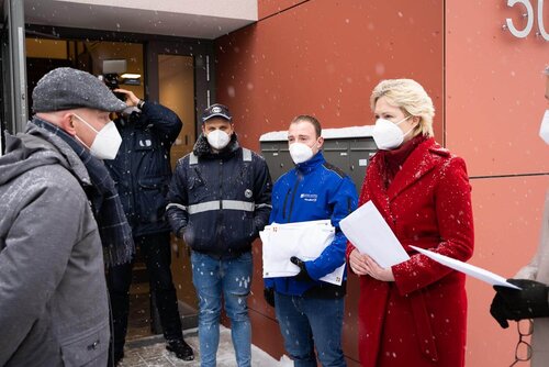 Manuela Schwesig und Dirk Ehmke stehen sich gegenüber und im Hintergrud zwei Zeitungsausträger