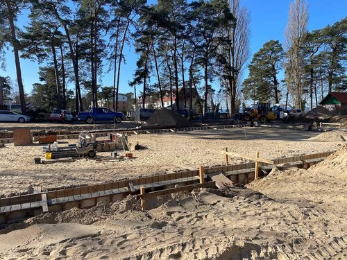 Ein großer ebener sandiger Platz mit einer niedrigen Umrüstung aus Holz