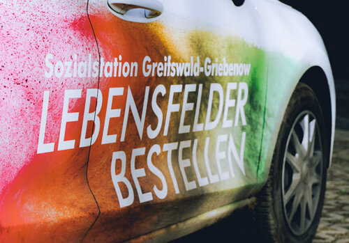 Ein Auto mit den Kontaktdaten des Pflegedienstes