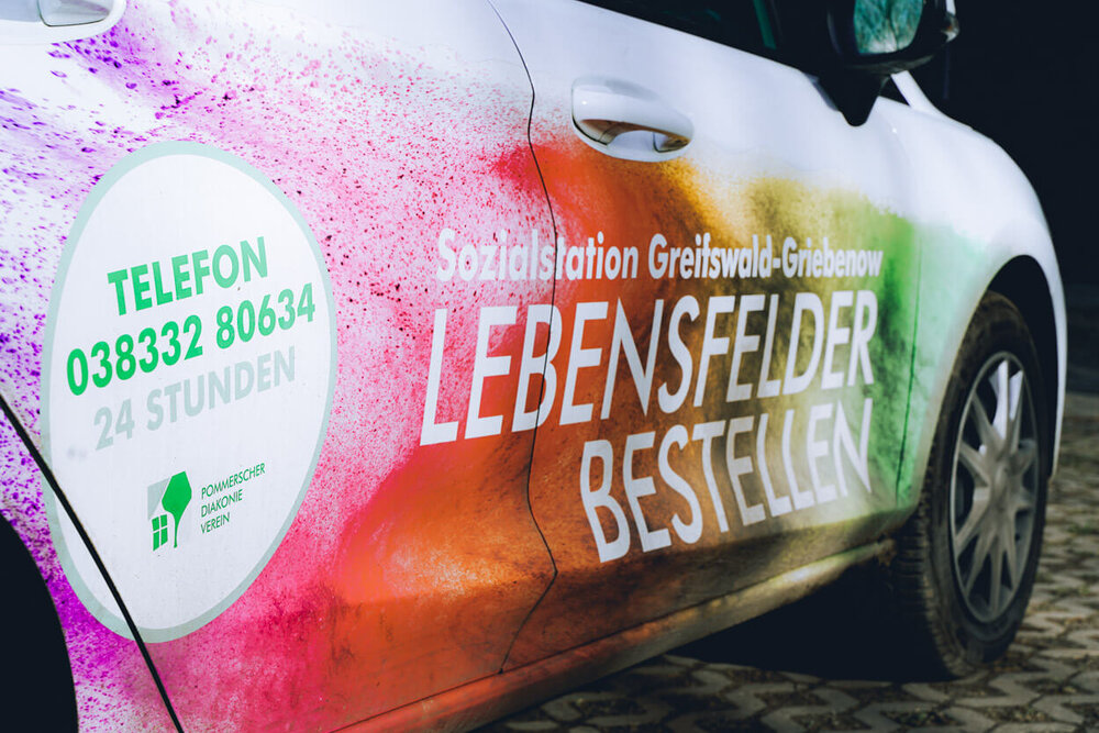 Ein Auto mit den Kontaktdaten des Pflegedienstes