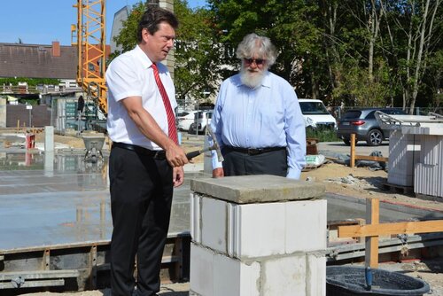 Ein Mann hält einen Hammer über einen großen Stein