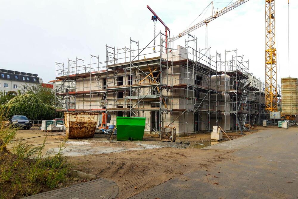Das Gebäude hat nun zwei Stockwerke. Ein großer Kran steht auf der Baustelle