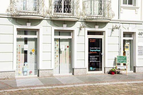 Ein weißes Gebäude mit einer Tür und der Aufschrift "Tagespflege Demmin"