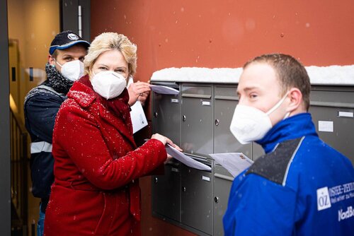 Frau Schwesig steht an einer Briefkastenanlage und wirft einen Umschlag hinein