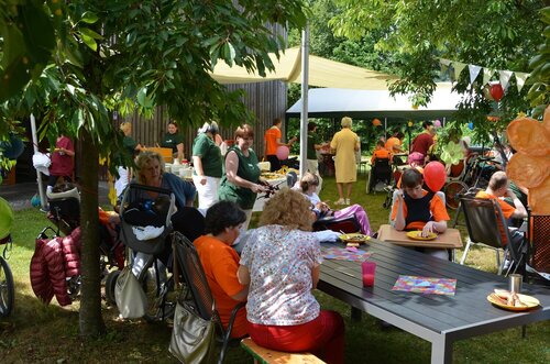 Im Garten sitzen Bewohner und Besucher beisammen