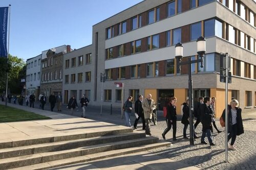 Teilnehmende an der Konferenz gehen vor dem Hauptgebäude des Pommerschen Diakonievereins