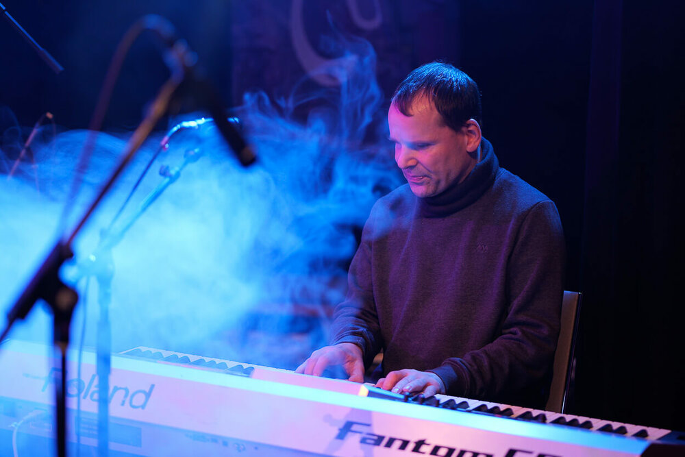 Marco Simanowski spielt Keyboard. Er ist umgeben von Effektnebel. 