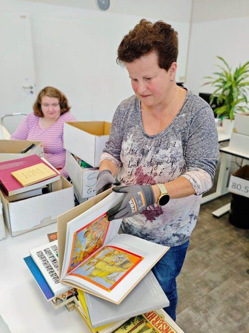 Eine Buchspende wird gesichtet und für den Versand vorbereitet.