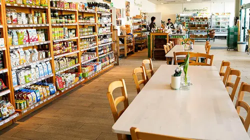 Große Esstische und volle Regale im Naturkostladen und Bio-Imbiss Pommerngrün in Greifswald.