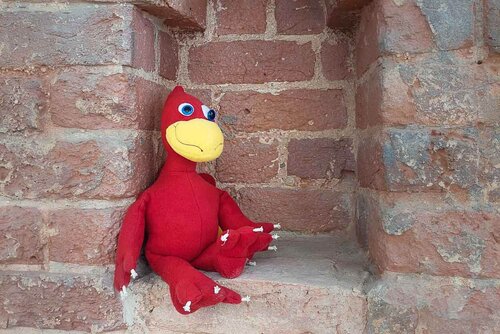 Ein Stofftier sitzt in einer Lücke alten Mauerwerks 