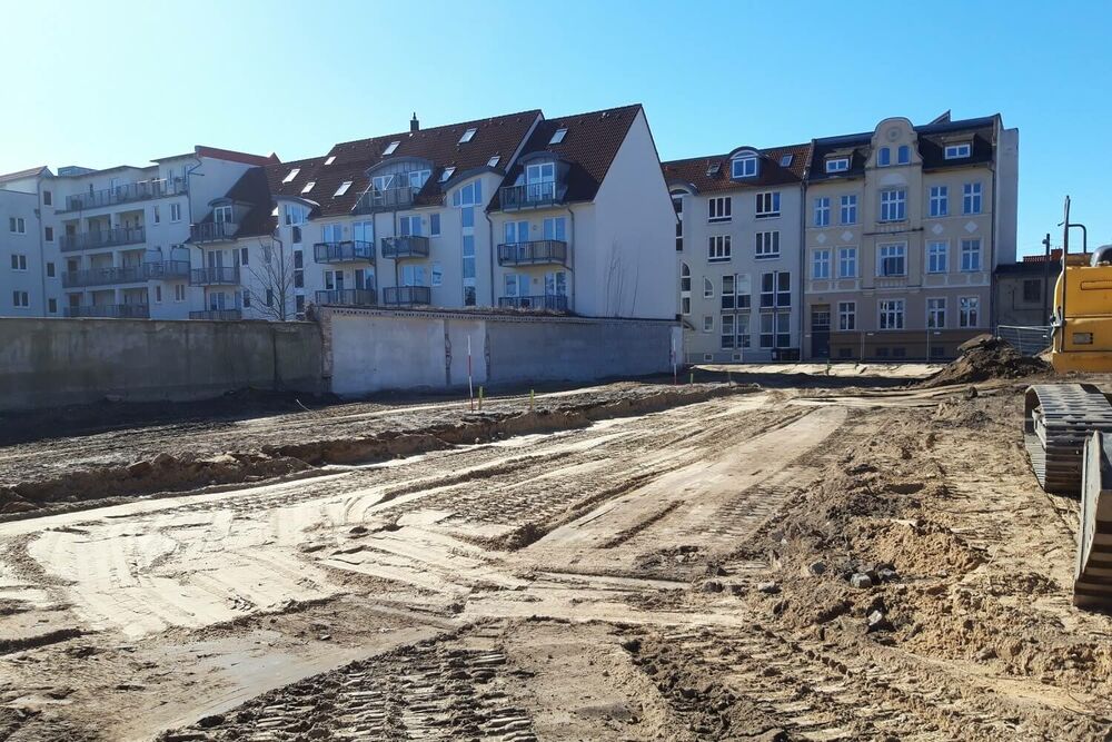 Einen sandigen Platz, in dem Bagger und große Geräte Spuren hinterlassen haben