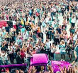 Blick in das Publikum Eine große Menschenmenge und ein altes Auto feiert