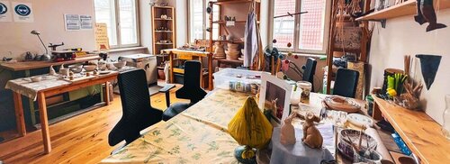 Ein Raum mit vielen Werkmöglichkeiten, Stühlen und Materialien