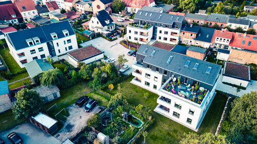 Eine Luftaufnahme von drei Wohnhäusern mit je drei Stockwerken und großen Balkonen in Ribnitz-Damgarten