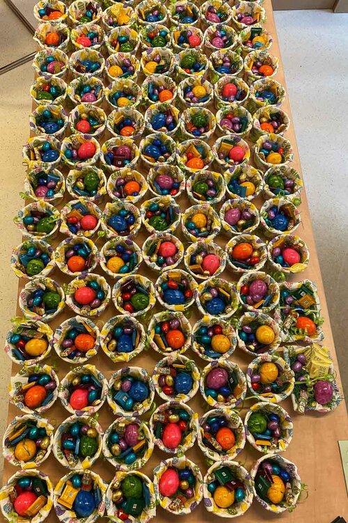 Auf einem Tisch stehen viele Osternester mit kleinen Schokoladen