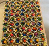 Auf einem Tisch stehen viele Osternester mit kleinen Schokoladen