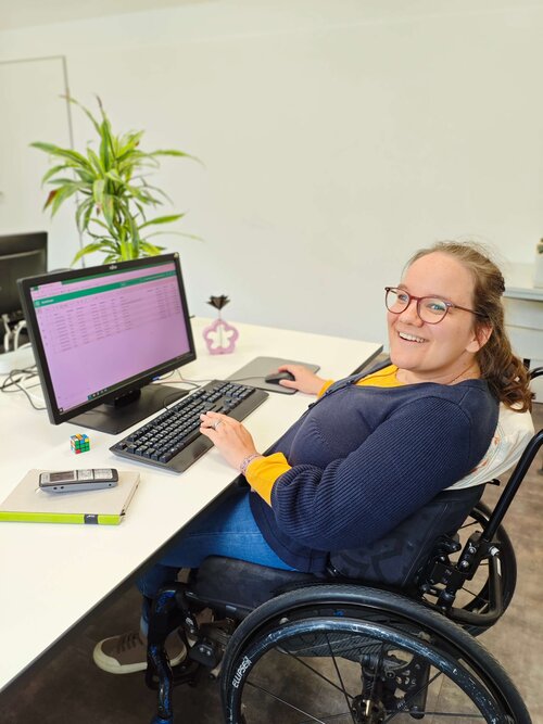 Eine Mitarbeiterin am PC vervollständigt Datensätze eines Kunden