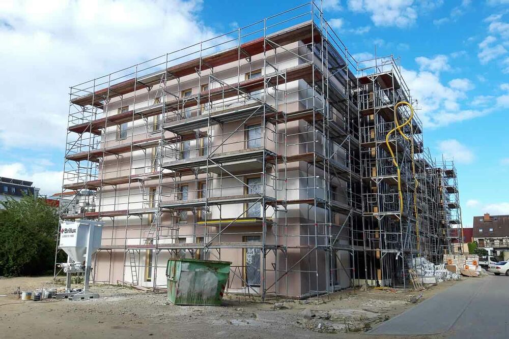 Das Gebäude steht, umgeben von einem Gerüst, jetzt fast fertig. 