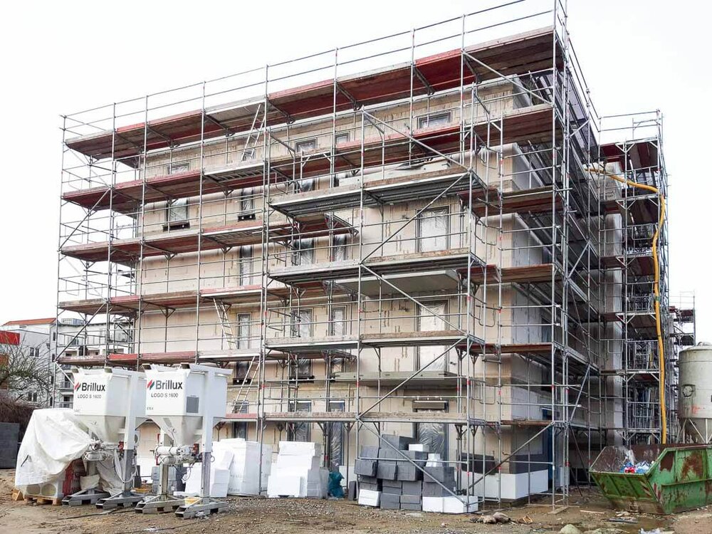 Der Neubau steht im Baugerüst und unten sind einige Platten angelehnt