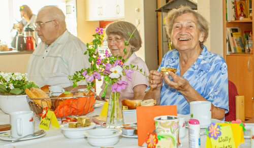 Bei einer gemeinsamen Mahlzeit Drei Personen sitzen an einem gedeckten Tisch