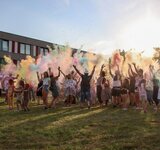 Eine große jubelnde Menge steht in einem Nebel aus Farben