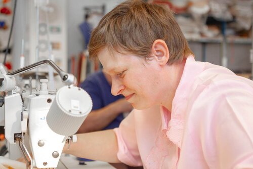 Eine Frau arbeitet an einer Maschine Frau an Nähmaschine