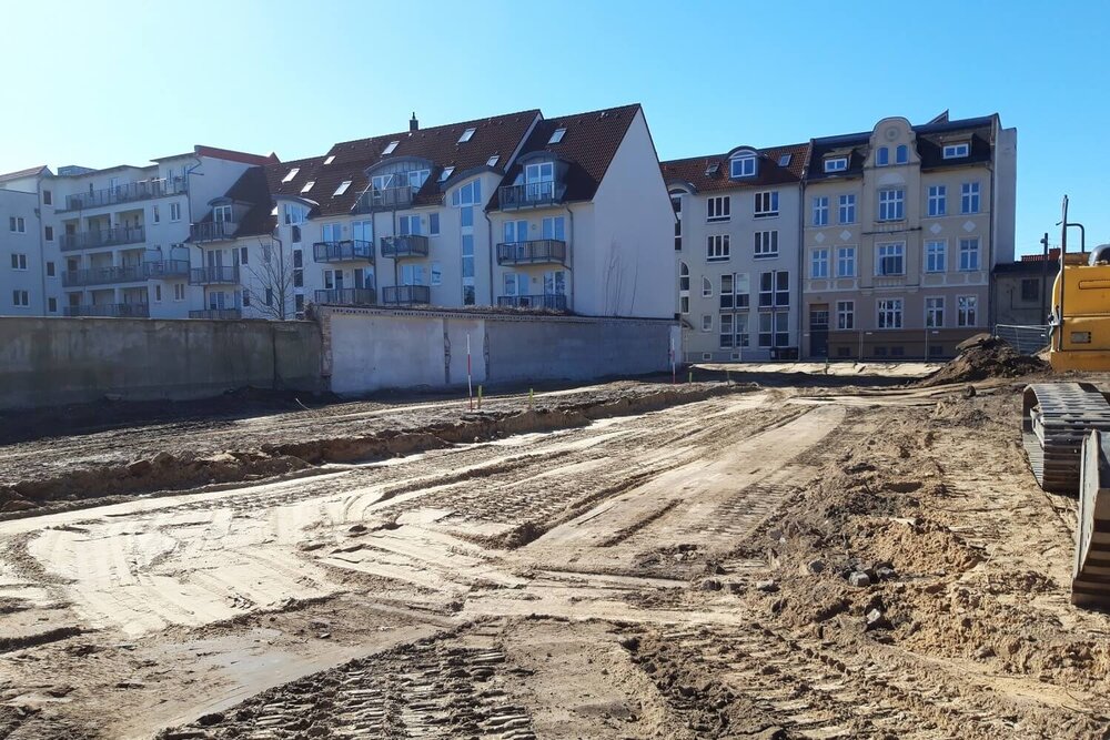 Einen sandigen Platz, in dem Bagger und große Geräte Spuren hinterlassen haben