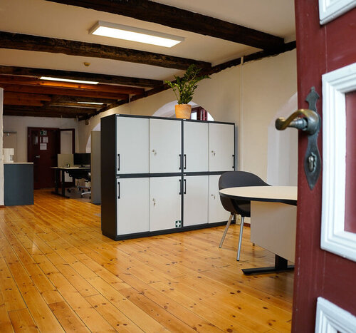 Geöffnete Tür und Hauseingang von Luka mit Willkommens-Schreibtisch