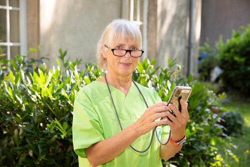 Eine Kollegin unseres Pflegedienstes in Greifswald macht Eingaben auf ihrem Smartphone.